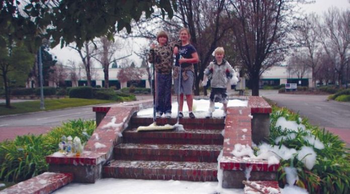 Three children clean soap from fountain
