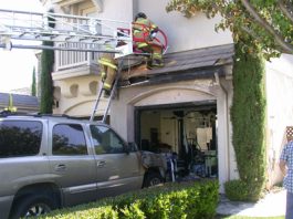 Parked vehicle catches fire, singeing home