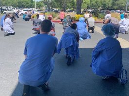 Saint Louise, county health workers take a knee