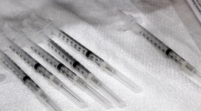 Flu season prompts advice from health officials covid-19 vaccine syringe dose booster