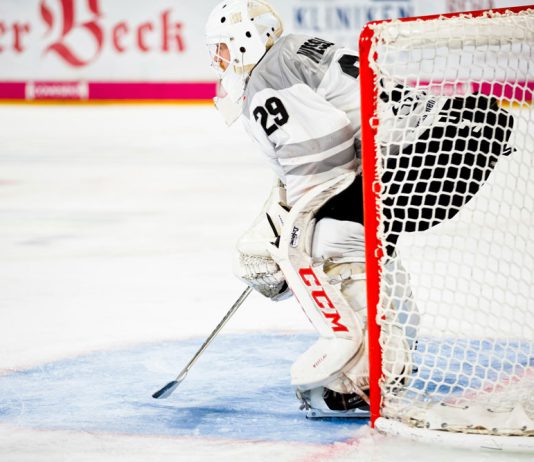 Dustin Wolf’s Stats and Records in the 2025 Season Icehockey goalkeeper standing in goal during a match