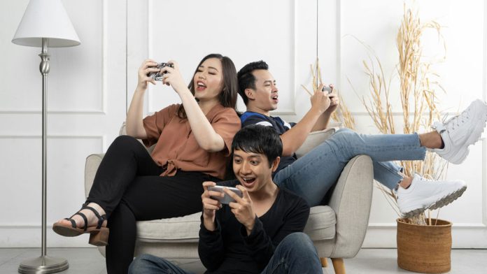 group of diverse friends playing games on mobile phone