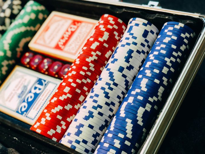 Red, blue, white, and green poker chips and poker cards.